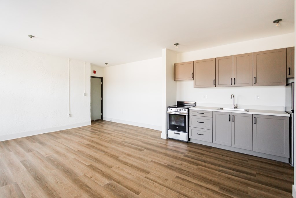 A kitchen with wooden floors and white walls.