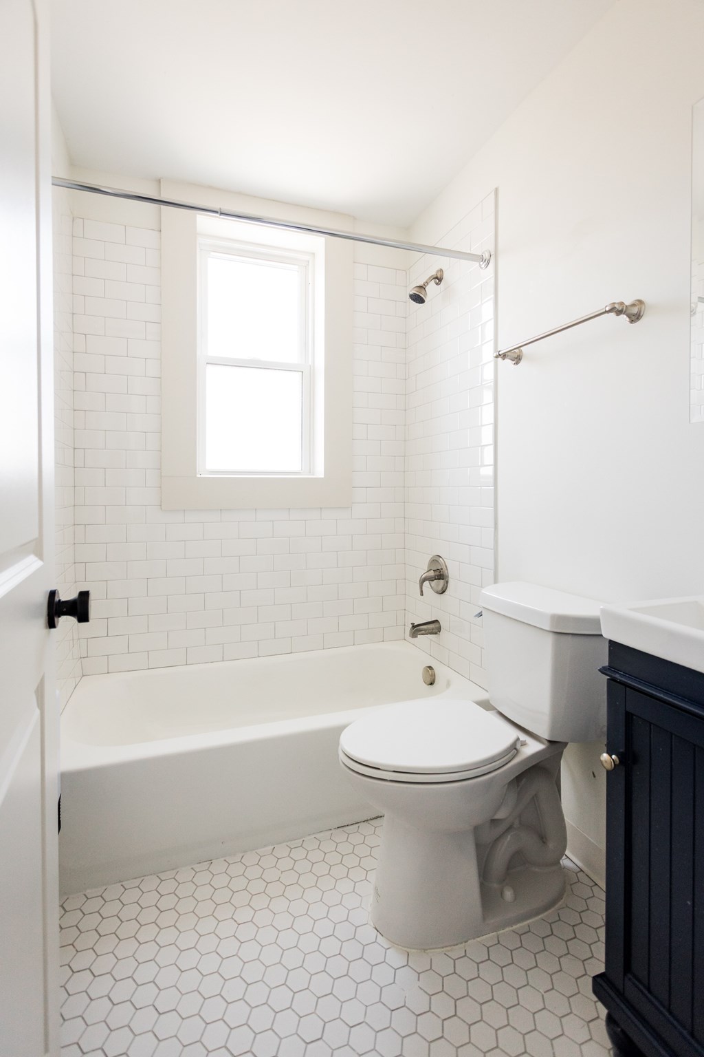 A white toilet in a bathroom with a black cabinet.