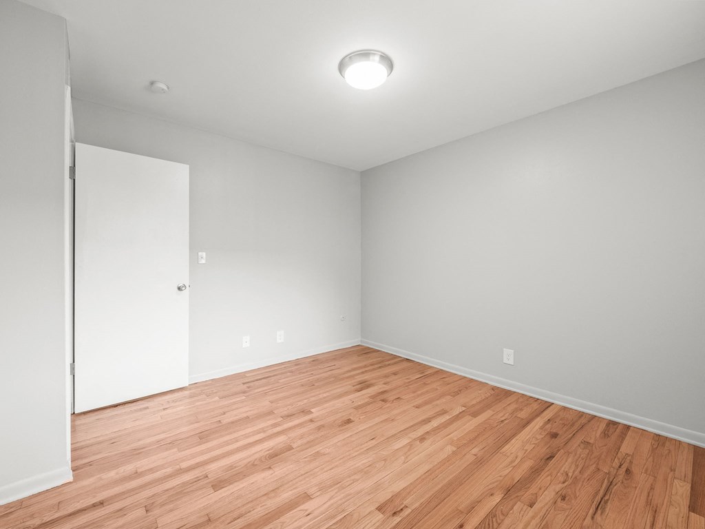 a bedroom with grey walls and a wooden floor
