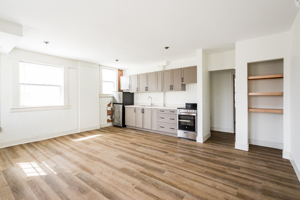 A kitchen with wooden floors and white walls.