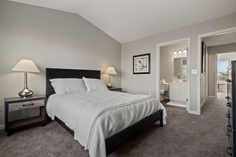 A bedroom with a bed, nightstand, and lamp.