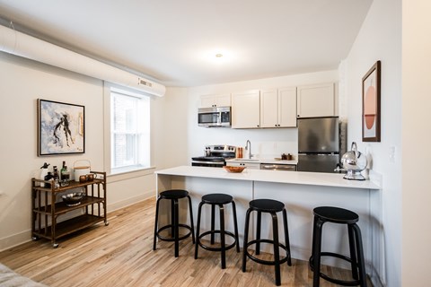A kitchen with white cabinets and a white counter top.