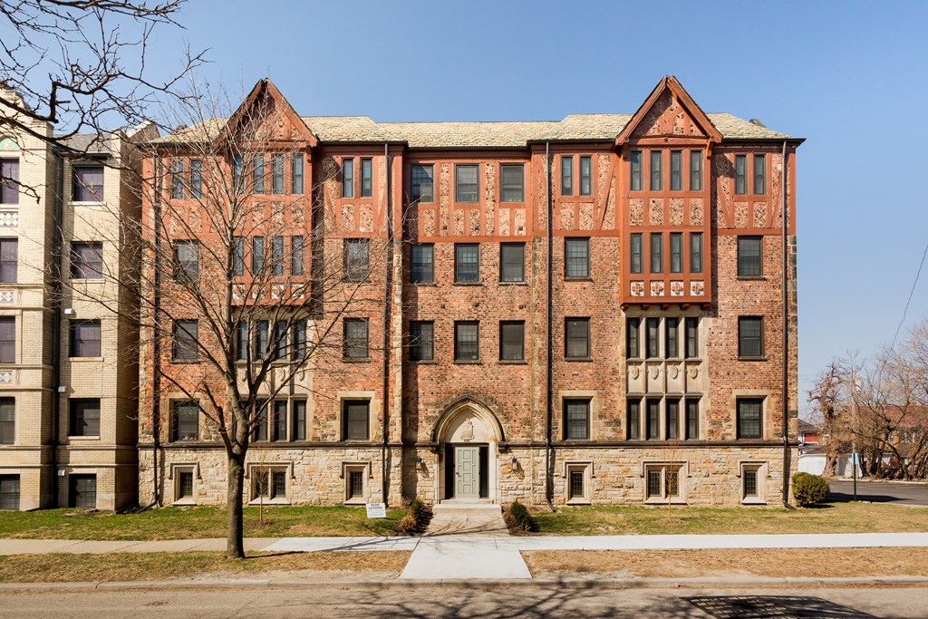 A large red brick building with a tree in front of it.