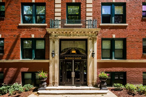 A red brick building with a black door and windows.