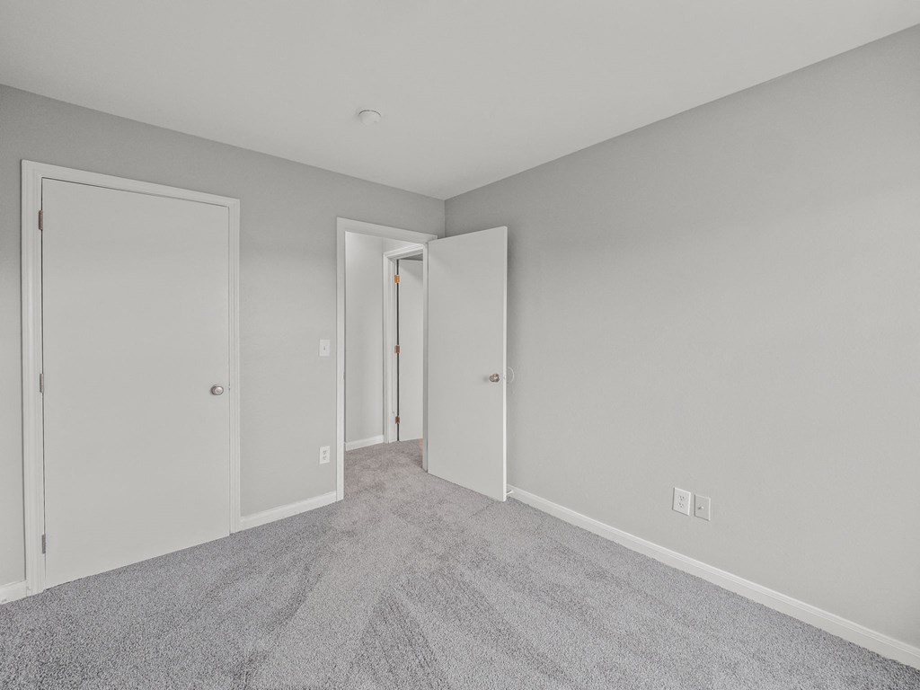 a bedroom with white walls and white doors