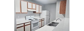A white stove and oven in a kitchen with white cabinets.