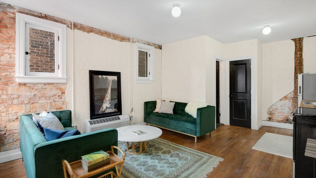 a living room with two green couches and a fireplace