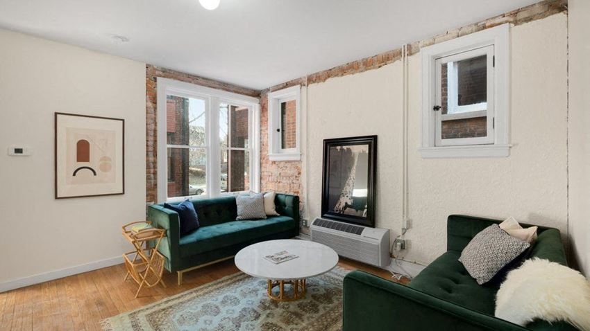 a living room with two green couches and a fireplace