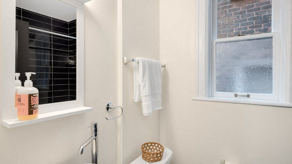 a bathroom with a window and a toilet and a towel