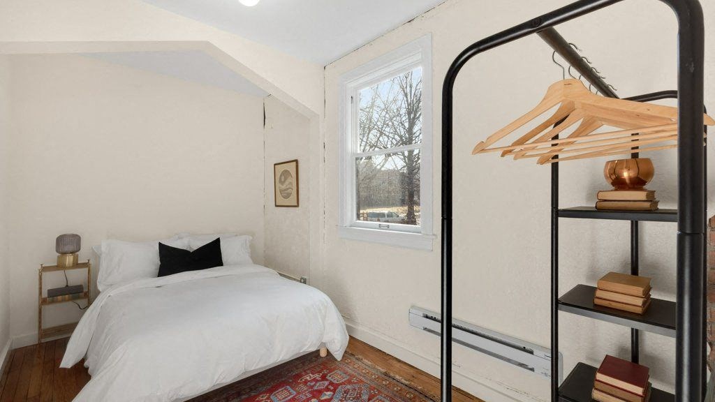 a white bedroom with a bed and a window