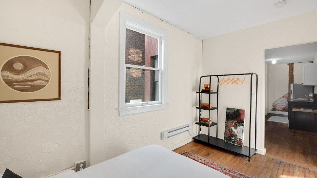 a bedroom with a white bed and a window