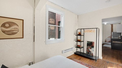 a bedroom with a white bed and a window