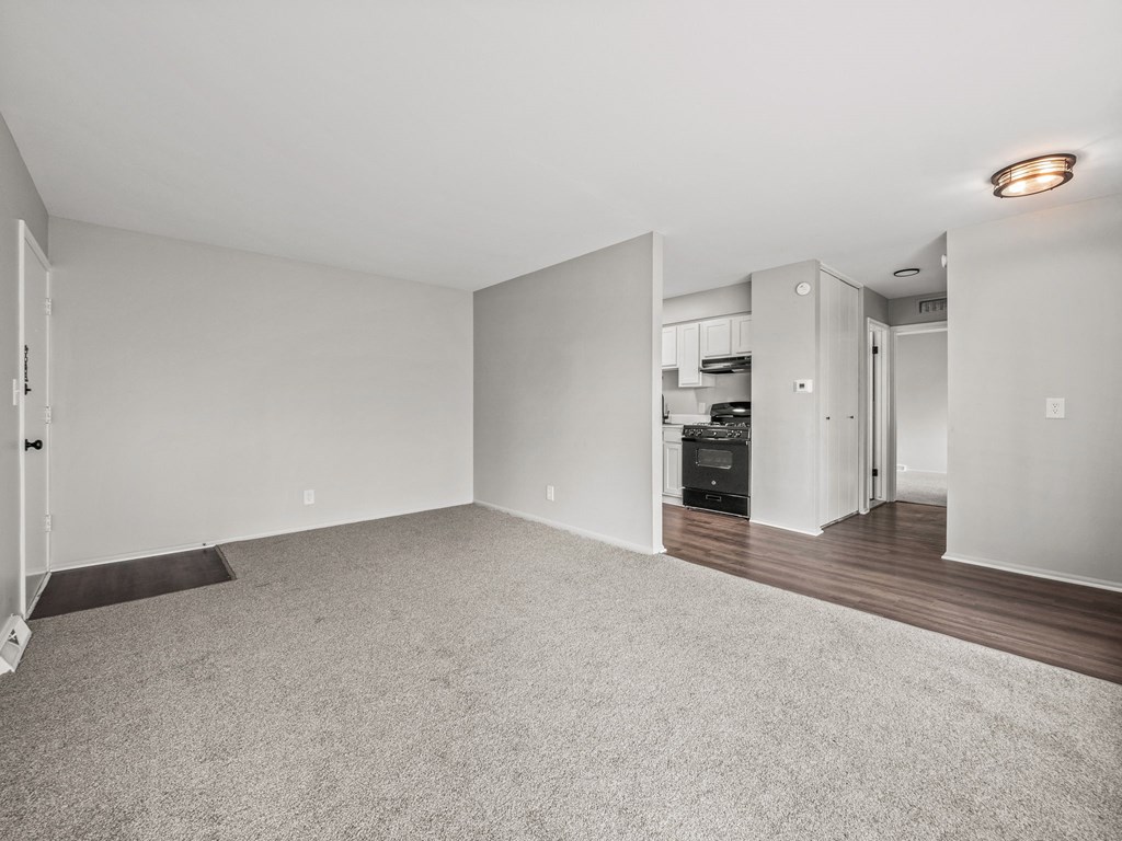 a bedroom with hardwood flooring and white walls