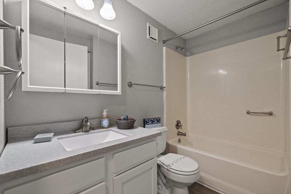 A bathroom with a sink, toilet, and bathtub.