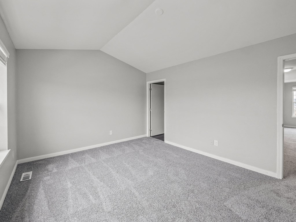 an empty room with carpet and a door to a closet