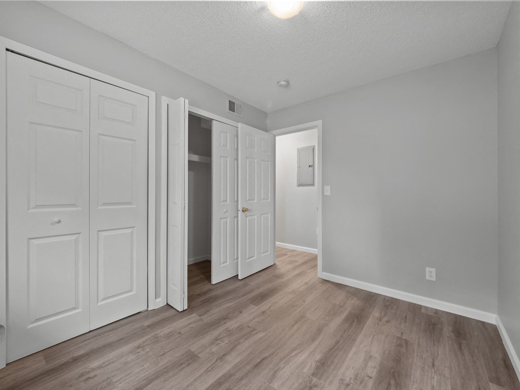 the living room of a renovated apartment with white doors and wood flooring