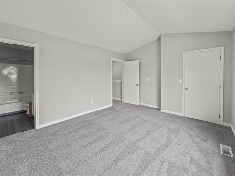 the living room of an apartment with carpet and white walls