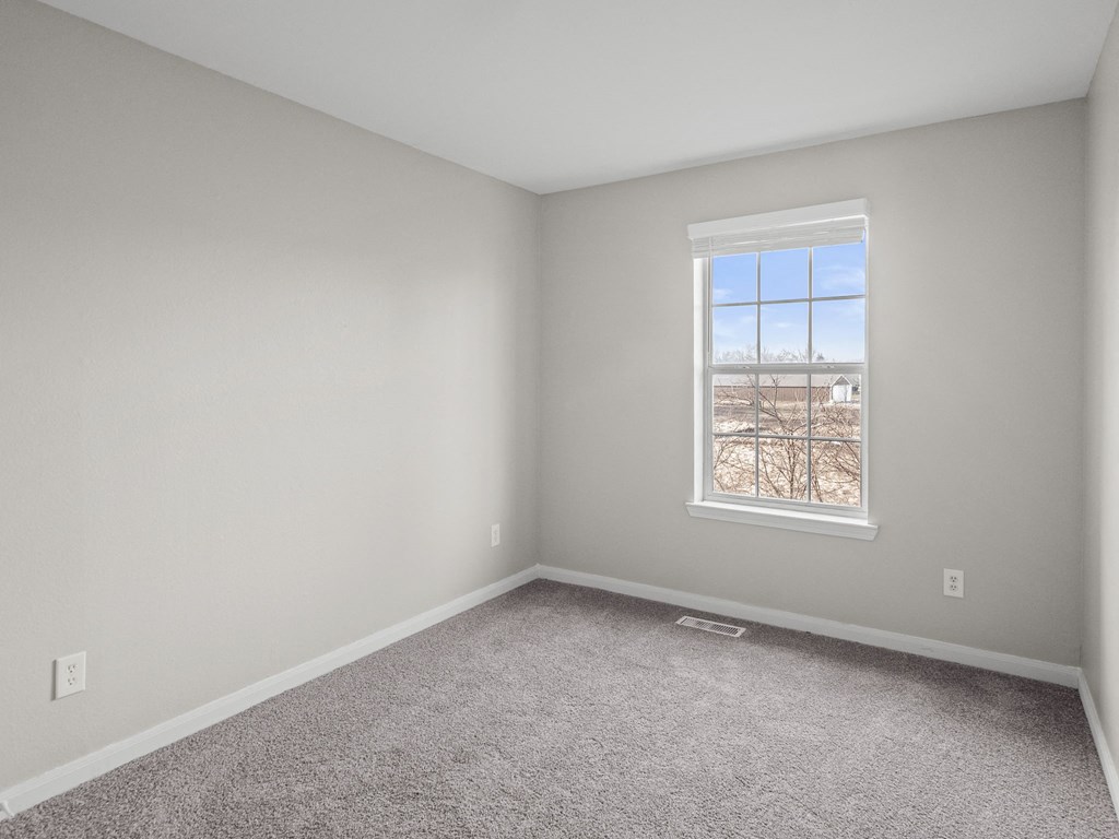 an empty room with carpet and a window