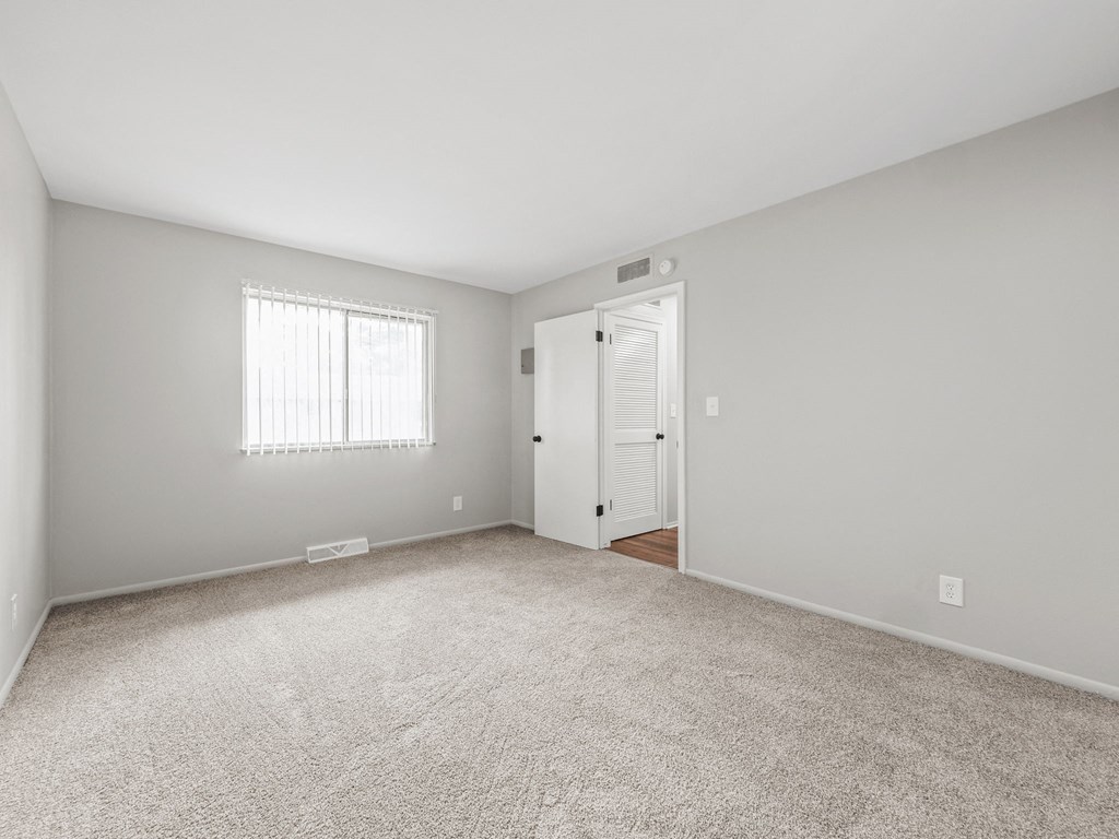 a bedroom with gray walls and a white carpet