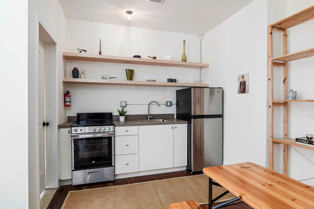 a small kitchen with white cabinets and stainless steel appliances