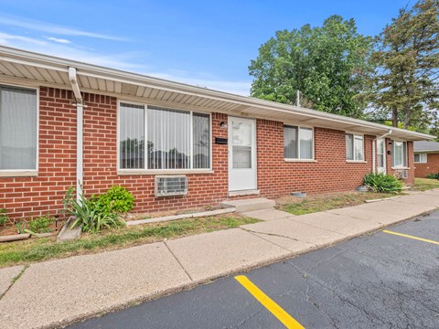 a brick building with a white door and a sidewalk