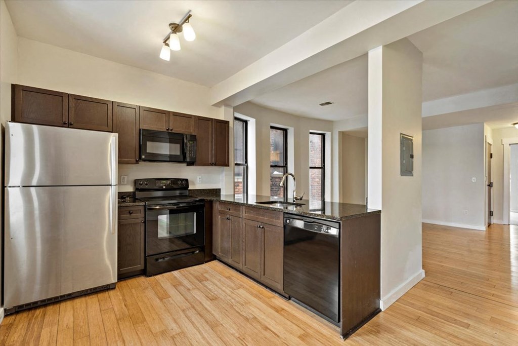 a kitchen with dark wood cabinets and stainless steel appliances
