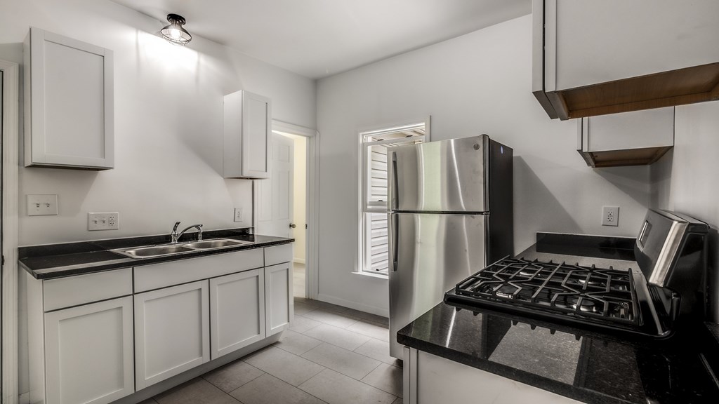 A modern kitchen with white cabinets and stainless steel appliances.