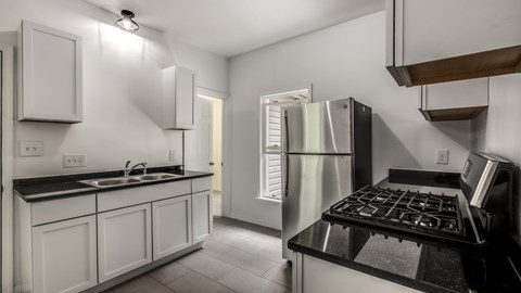 A modern kitchen with white cabinets and stainless steel appliances.