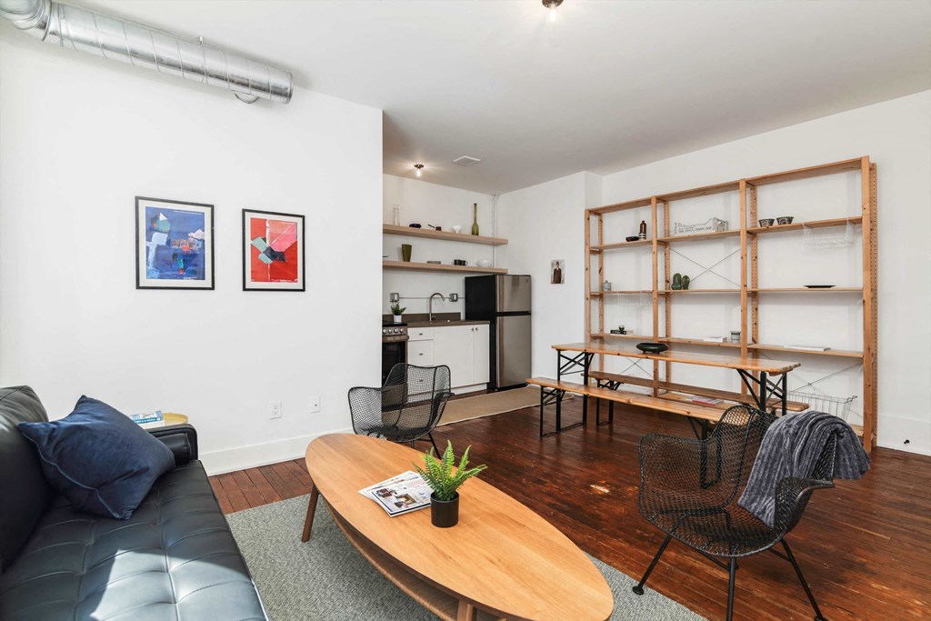 a living room with white walls and hardwood floors