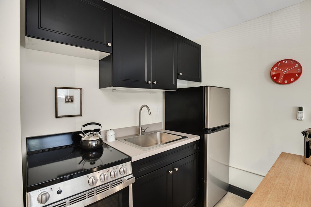 A black stove top oven with a kettle on it.