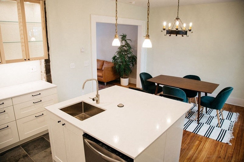 a white kitchen with a sink and a table