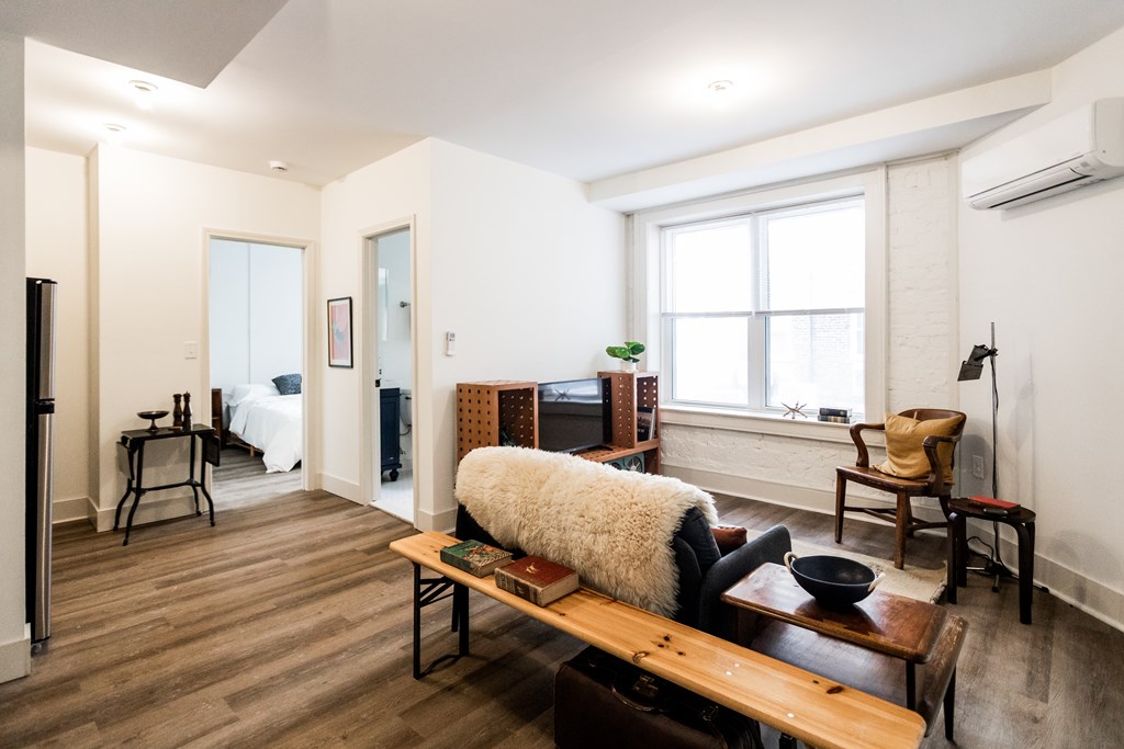 A living room with a brown bench and a black bowl on it.