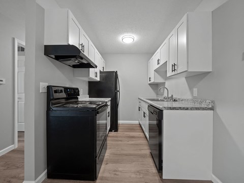 a kitchen with white cabinets and a black stove and refrigerator