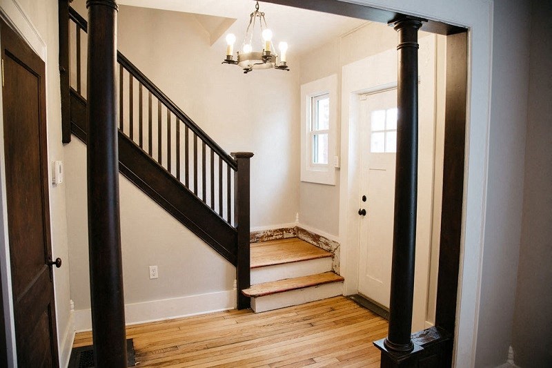 a staircase in a house with a door and a wooden floor