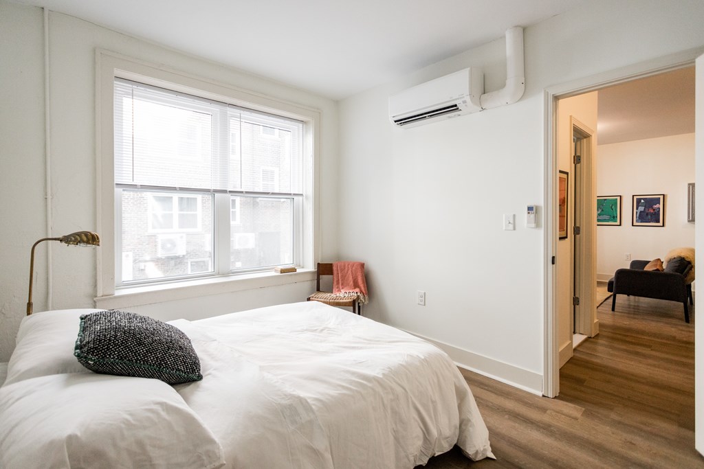 A bedroom with a large bed and a window.