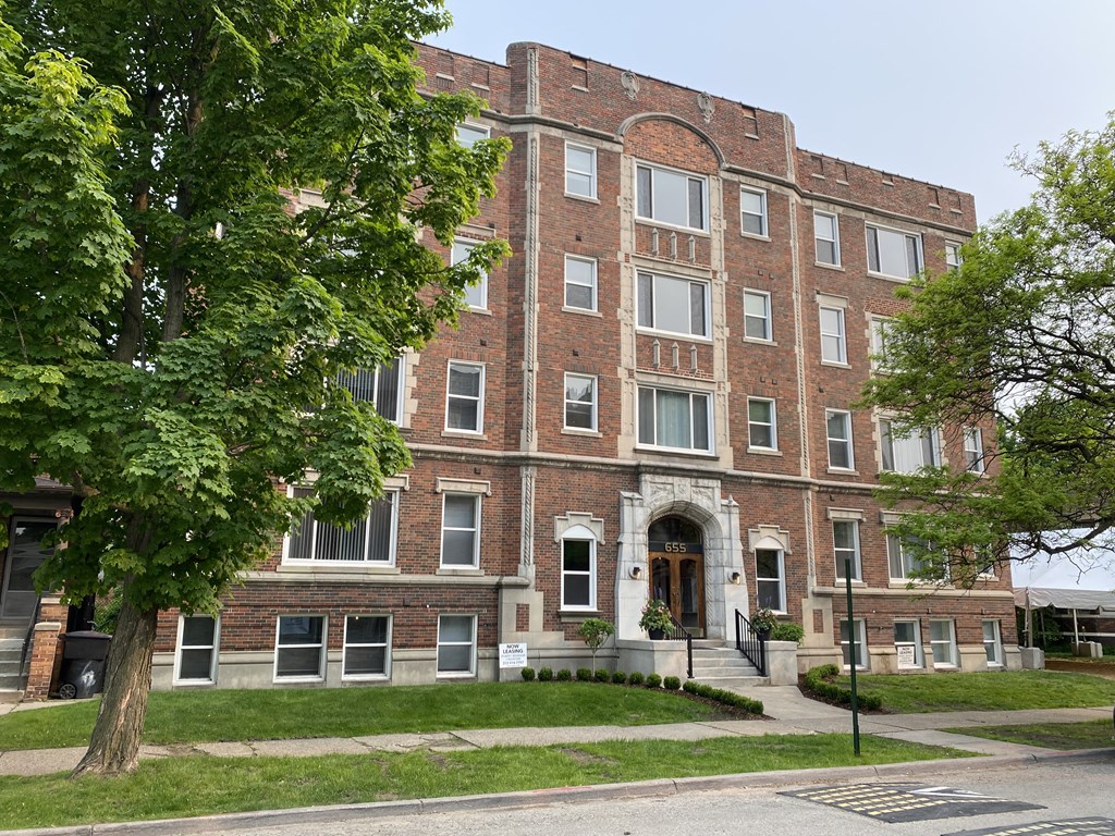 a red brick building with a tree in front of it