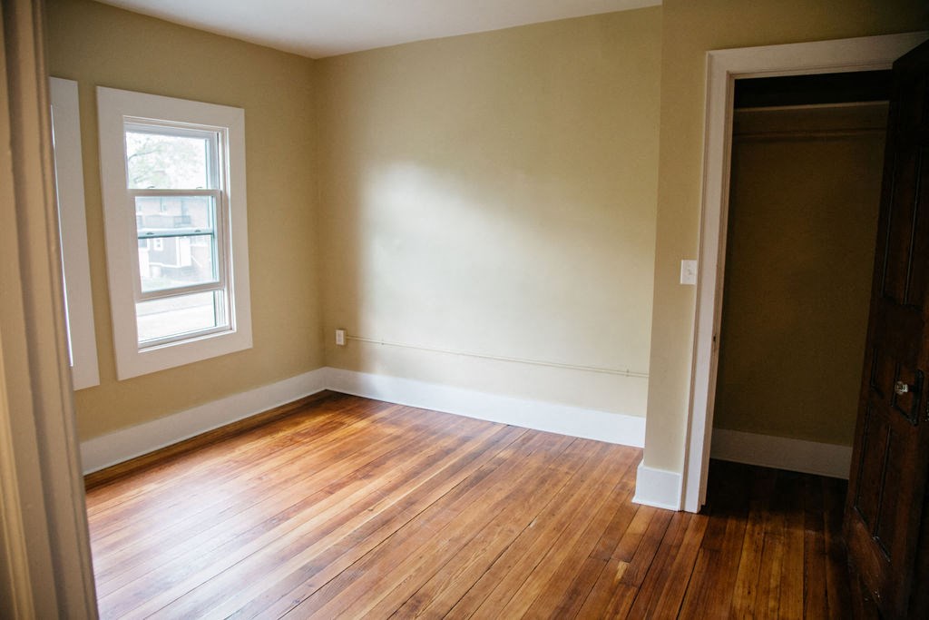 an empty room with wooden floors and a window