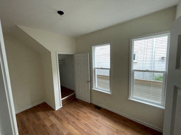 an empty room with a door and two windows
