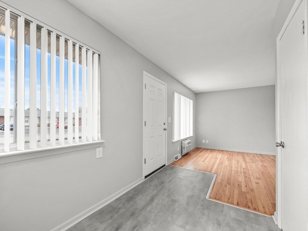 a bedroom with hardwood floors and grey walls