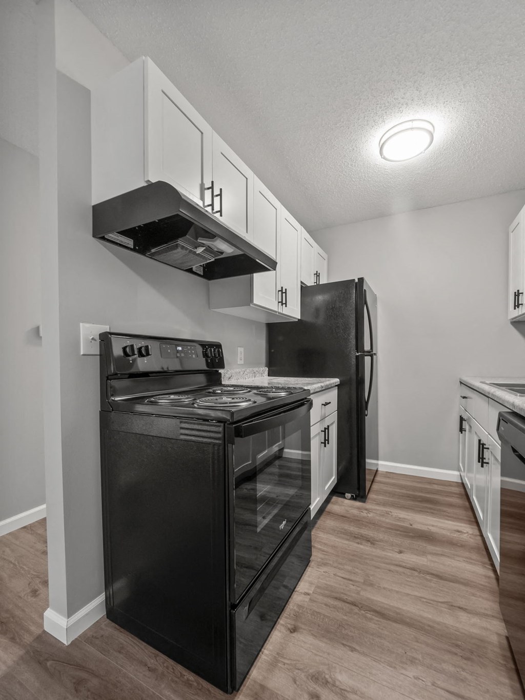 a kitchen with black appliances and white cabinets