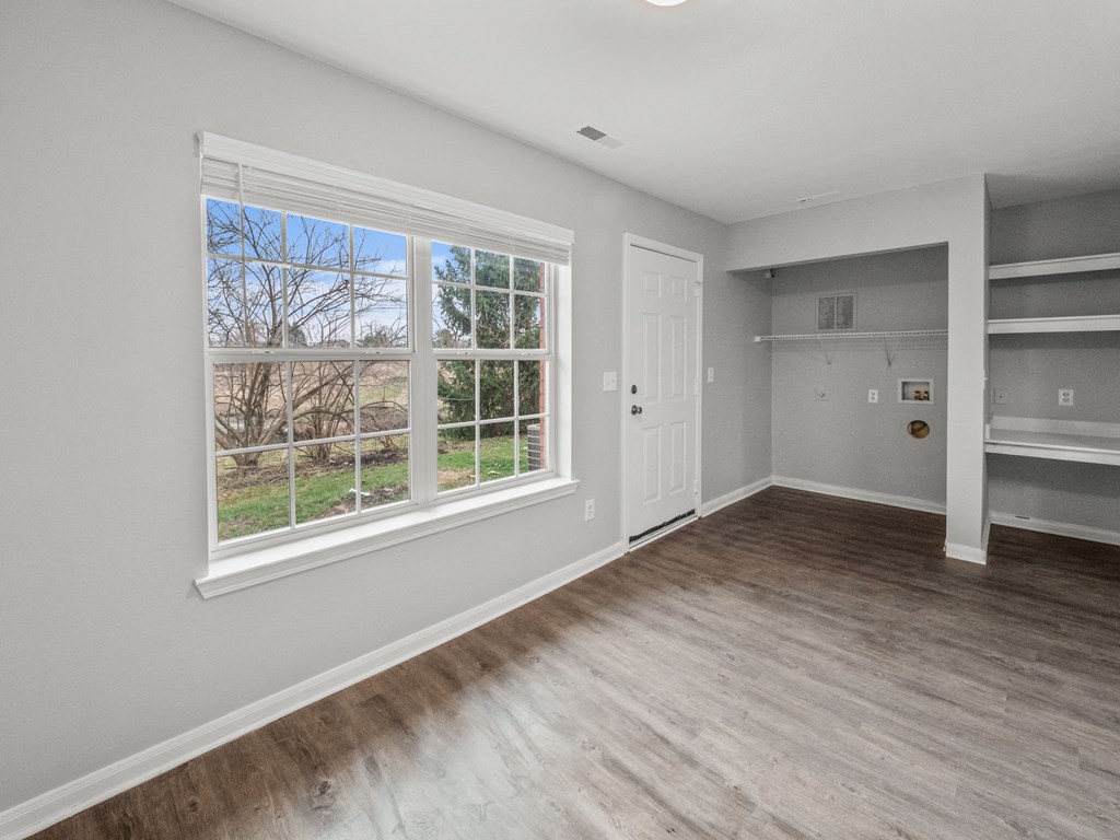 a living room with a large window and wooden floors