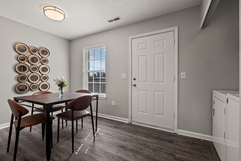 A dining room with a table and chairs.