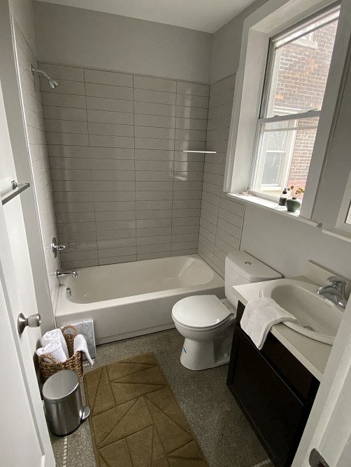a bathroom with a toilet and a tub and a sink