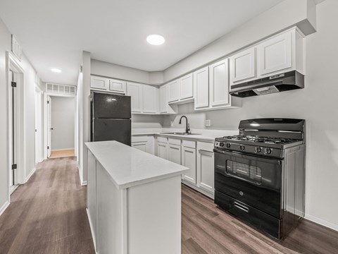 the kitchen of a new home with white cabinets and black appliances