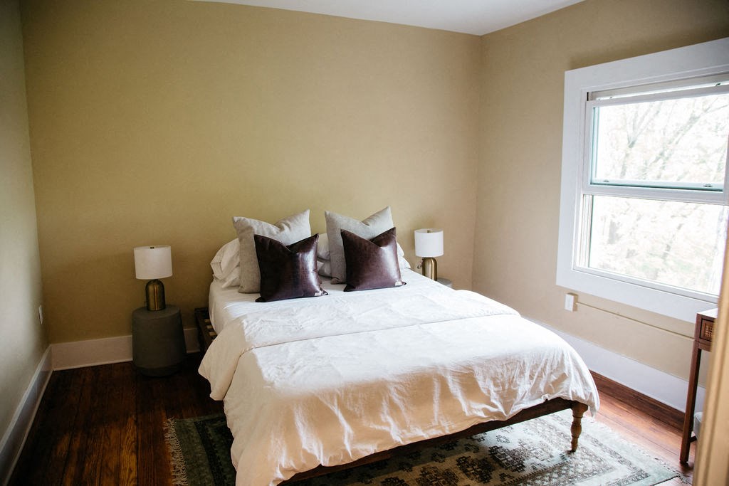 a bedroom with a bed and two windows