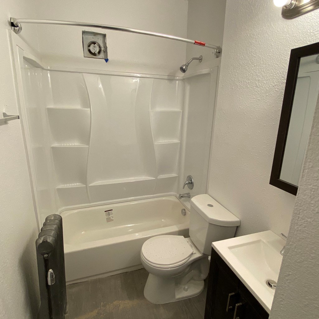 a bathroom with a toilet and a tub and a sink