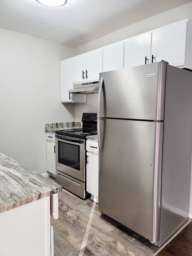 a kitchen with stainless steel appliances and white cabinets