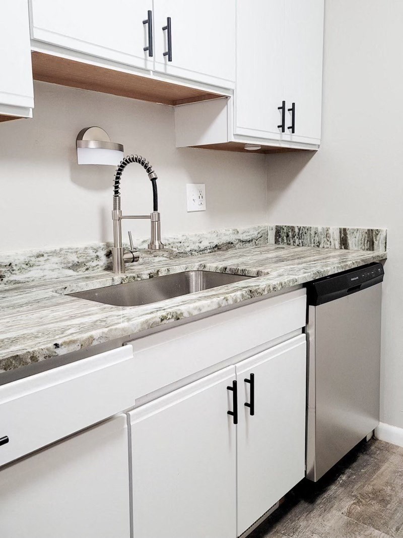a kitchen with white cabinets and a sink