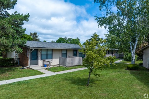 a home with a porch and a tree in front of it