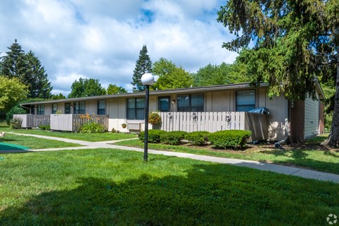 a white house with a yard and sidewalk in front of it